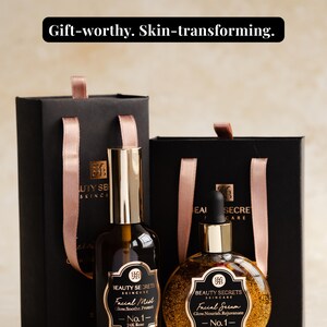 Puede incluir: Dos bolsas de regalo negras con asas de cinta rosa y dos frascos de cuidado facial. Un frasco alto etiquetado Facial Mist 3.4oz y uno redondo etiquetado Facial Serum 1.7oz, ambos con detalles dorados y el texto 24K Rose Radiance Ritual.