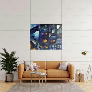 Könnte beinhalten: Abstraktes Kunstwerk mit geometrischem Design in Blau-, Gold- und Weißtönen. Das Kunstwerk hängt über einem beigefarbenen Ledersofa mit grauen Kissen. Eine Topfpflanze und eine Stehlampe sind ebenfalls zu sehen.