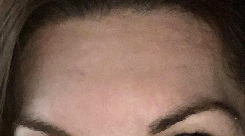 Peut inclure: Gros plan sur le front, les sourcils et une partie des yeux d'une personne. Le teint est clair avec quelques taches de rousseur. Les sourcils sont brun fonc&eacute; et les cheveux sont d'une nuance de brun plus fonc&eacute;e.