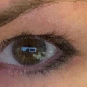 Peut inclure: Gros plan sur un &oelig;il humain avec un iris brun et des cils fonc&eacute;s. L'&oelig;il refl&egrave;te une image floue d'une pi&egrave;ce avec une fen&ecirc;tre et des meubles. La peau autour de l'&oelig;il est brun clair.