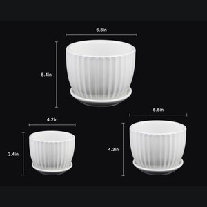 May include: Three white ceramic planters with matching saucers. The largest planter is 6.8 inches wide and 5.4 inches tall. The medium planter is 5.5 inches wide and 4.3 inches tall. The smallest planter is 4.2 inches wide and 3.4 inches tall.