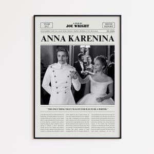 May include: A framed black and white movie poster for "Anna Karenina" (2012) by Joe Wright. The poster features a still from the film with two actors in period costumes. The poster includes the movie title, credits, and a quote.