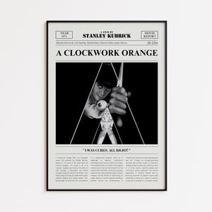 Op de afbeelding: Zwart-wit ingelijste filmposter voor "A Clockwork Orange" van Stanley Kubrick. De poster toont de titel van de film, de credits en een centrale afbeelding van een personage dat een wapen vasthoudt, met de tekst "I WAS CURED, ALL RIGHT!"