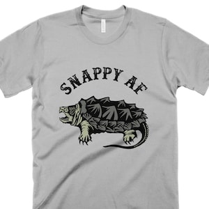 May include: A gray t-shirt with a black and green snapping turtle graphic and the text "Snappy AF" in black.