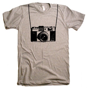May include: A heather grey t-shirt with a black and white illustration of a vintage camera hanging from a strap.