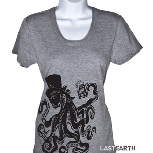 May include: A gray t-shirt with a black and white illustration of an octopus wearing a top hat and holding a beer mug. The octopus has eight tentacles and is in a relaxed pose. The text "LASTEARTH" is printed on the bottom right corner of the shirt.