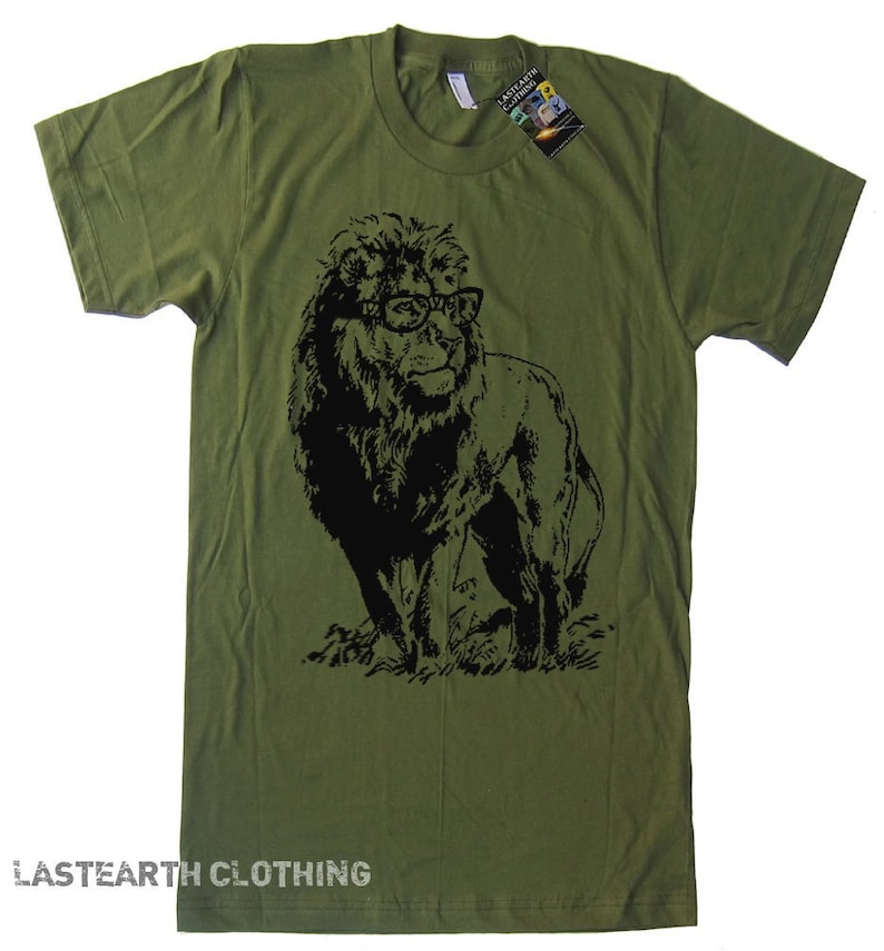 May include: A green t-shirt with a black and white illustration of a lion wearing glasses. The lion is looking to the right. The t-shirt has the text "LASTEARTH CLOTHING" at the bottom.