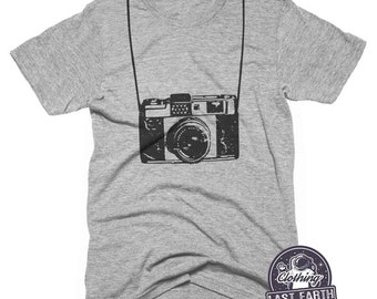 May include: A heather grey t-shirt with a black and white illustration of a vintage camera with a strap. The camera is centered on the shirt.