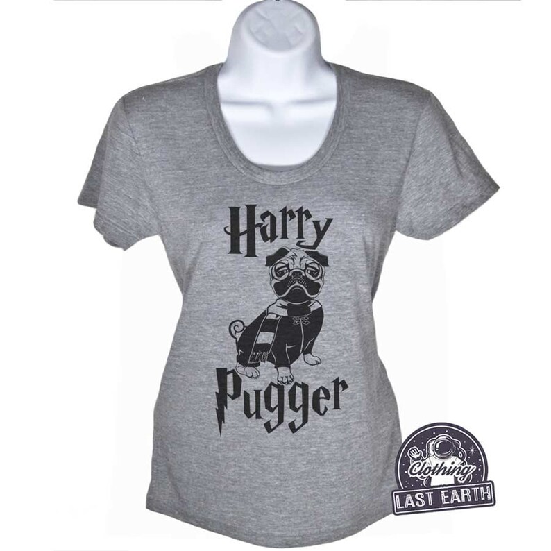 May include: A gray t-shirt with a black graphic of a pug wearing glasses and a scarf. The text "Harry Pugger" is printed on the shirt with a lightning bolt.