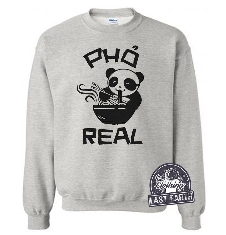 May include: A grey sweatshirt with a black graphic of a panda eating pho. The text "Pho Real" is printed below the panda.