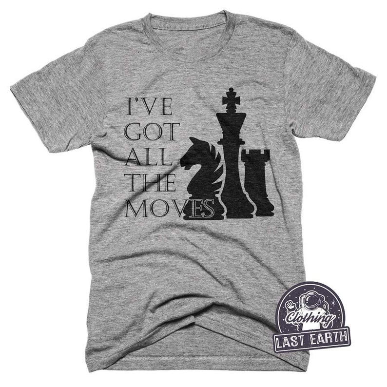 May include: A heather grey t-shirt with a black chess piece graphic and the text "I've got all the moves".