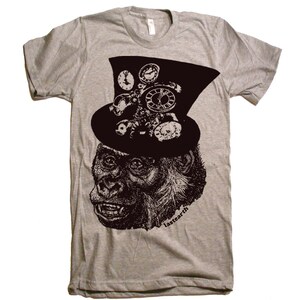 May include: A gray t-shirt with a black and white illustration of a gorilla wearing a top hat with gears and clock faces. The text "lastearth" is printed on the bottom right corner of the shirt.