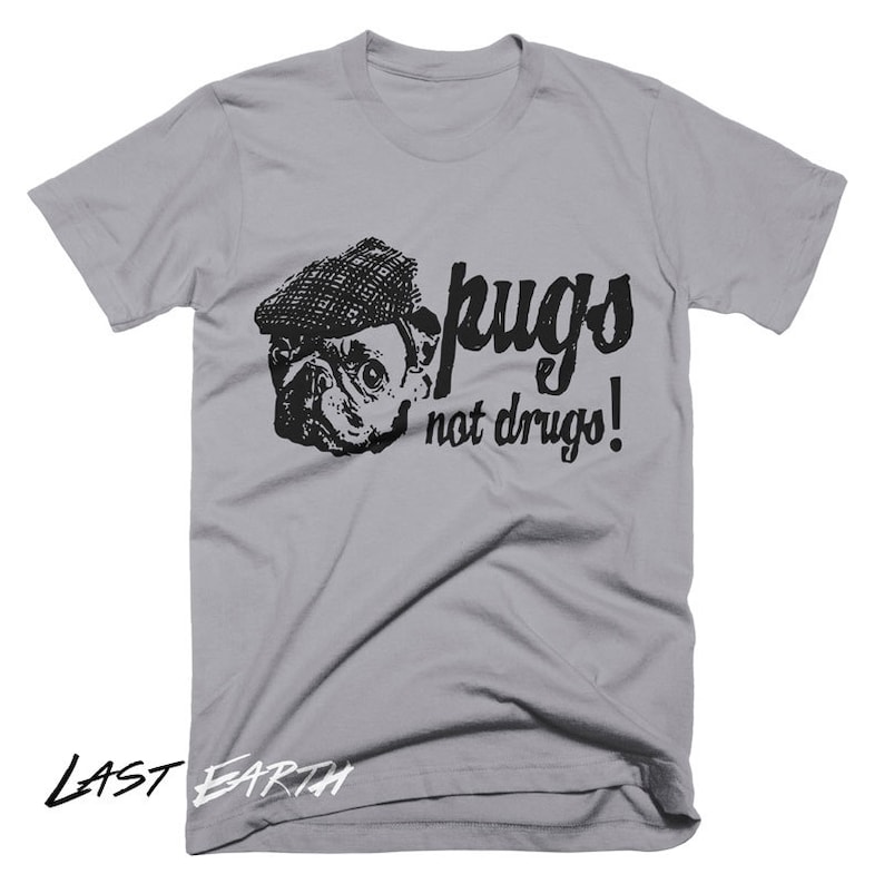 Puede incluir: Una camiseta gris con una imagen en blanco y negro de un carlino con un sombrero. El texto "pugs not drugs!" est&aacute; impreso en la camiseta.
