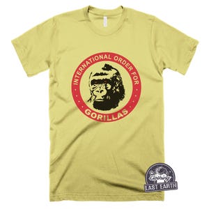 May include: A yellow t-shirt with a red circle and the text "International Order for Gorillas" in red. A black and white gorilla with red eyes is inside the circle.