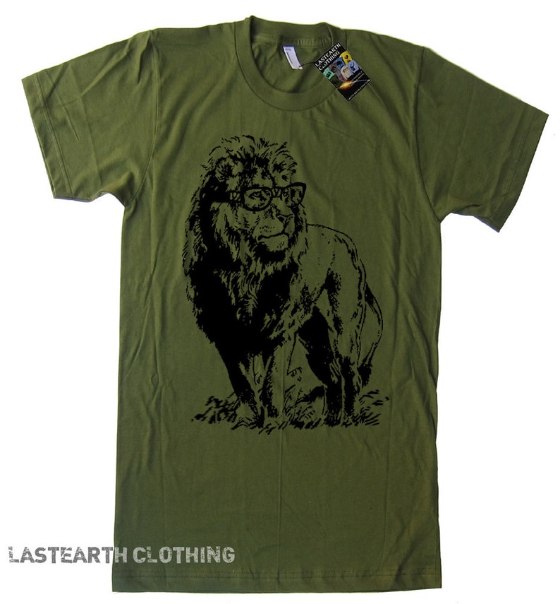 May include: A green t-shirt featuring a black silhouette of a lion wearing glasses. The text "LASTEARTH CLOTHING" is printed on the bottom of the shirt.