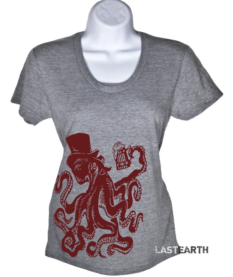 May include: A gray t-shirt with a red octopus wearing a top hat and holding a beer mug. The octopus is in a vintage style illustration. The text "LASTEARTH" is printed on the bottom right corner of the shirt.