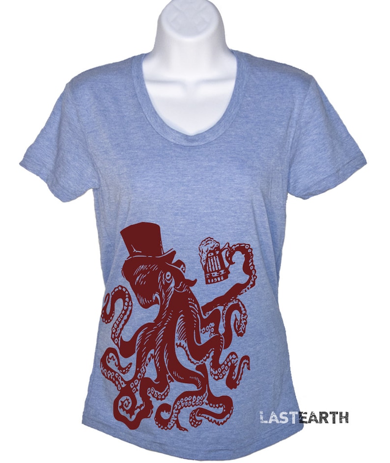 May include: A light blue t-shirt with a red octopus wearing a top hat and holding a beer mug. The octopus is in a vintage style illustration. The text "LASTEARTH" is on the bottom right corner of the shirt.