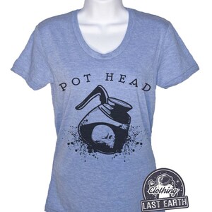 Puede incluir: Una camiseta azul claro con un gr&aacute;fico negro de una cafetera con una calavera en su interior. El texto "POT HEAD" est&aacute; impreso sobre el gr&aacute;fico. La camiseta es de la marca "Last Earth Clothing."