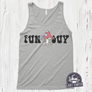 K&ouml;nnte beinhalten: Ein graues Tanktop mit dem Text "FUN GUY" in schwarzen Buchstaben mit einer Retro-Schrift. Unter dem Text befindet sich ein Cartoon-Bild von drei Pilzen. Die Pilze sind rot, wei&szlig; und blau.