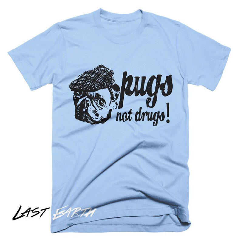 Puede incluir: Camiseta azul claro con una imagen en blanco y negro de un carlino con un sombrero y el texto "pugs not drugs!"