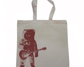 May include: A white tote bag with a red print of an astronaut playing a guitar.