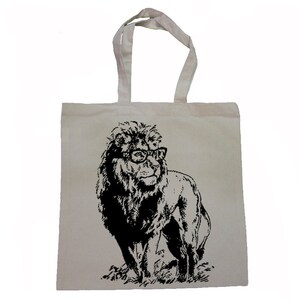 May include: A white canvas tote bag featuring a black and white illustration of a lion wearing glasses. The lion is looking to the right.