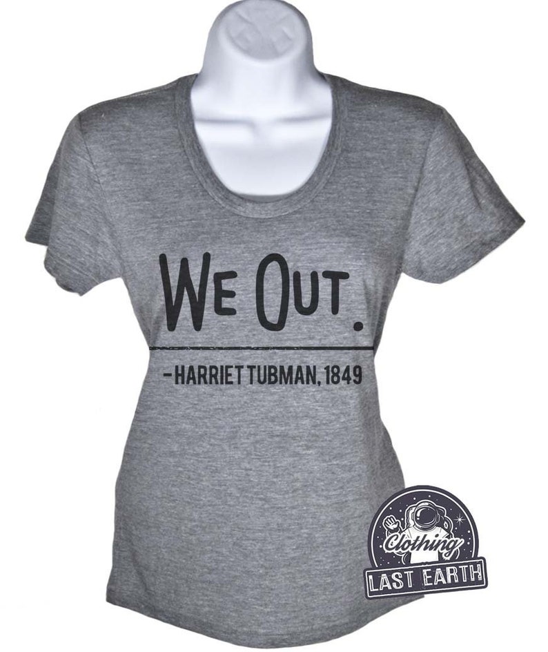 Puede incluir: Una camiseta gris jaspeada con texto negro que dice "We Out. -Harriet Tubman, 1849".