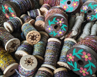 Hilos y estambres hilados a mano en bobinas adornadas para su arte en fibra: tapices teñidos a mano, tejidos a mano, bordados, lanas, sedas y hilados artísticos.