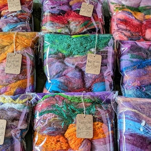 May include: Assortment of colorful recycled art batt fiber in clear plastic bags with brown paper tags that say "Recycled Art Batt".