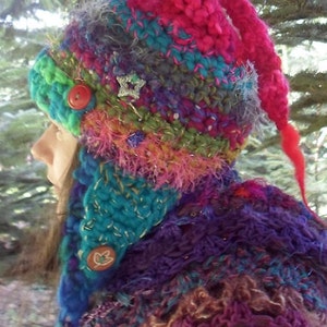 May include: A colourful crocheted hat with a long tail, featuring a variety of textures and embellishments, including buttons and stars.