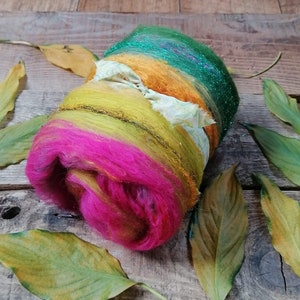 May include: A colorful ball of yarn with green, yellow, orange, and pink shades. The yarn is wrapped around itself and has a sparkly green layer on the outside.