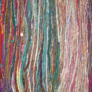 May include: A collection of colorful, hand-crafted dreadlocks made from wool yarn. The dreadlocks are arranged in a vertical row and feature a variety of colors, including red, blue, green, purple, and brown.