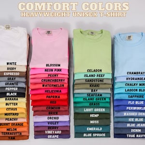 May include: Stacks of heavyweight unisex t-shirts in various colors, including white, pink, green, and blue. Each stack displays a different color with its corresponding name, such as "Blossom," "Celadon," and "Chambray."