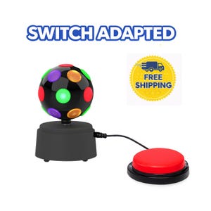 May include: A black disco ball with colorful lights sits atop a black base, connected by a wire to a large red button. The text "SWITCH ADAPTED" is above the disco ball.