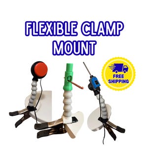 May include: Three flexible clamp mounts with grey segmented arms and black metal clamps. One features a red circular button, one a green cylindrical top with a copper wire, and one a blue rectangular switch with a thin metal rod. Text reads FLEXIBLE CLAMP MOUNT.