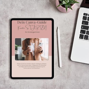 Könnte beinhalten: Ein digitales Tablet mit einem Leitfaden mit dem Titel "Dein Canva-Guide Kreativ STARTEN für Einsteigerinnen" in deutscher Sprache. Der Bildschirm zeigt ein Bild einer Person, die eine Kaffeetasse und ein Telefon hält. Ein weißer Stift und ein Laptop sind ebenfalls sichtbar.