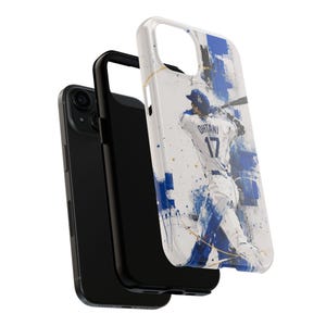 Puede incluir: Un smartphone negro con una funda protectora que presenta una representación artística en azul y blanco de un jugador de béisbol en acción. La camiseta del jugador muestra el nombre "Ohtani" y el número "17".