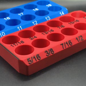 May include: Two 3D-printed organizers, one red and one blue. The red organizer has holes labeled with fractions like 5/16, 3/8, and 7/16. The blue organizer has numbers 10 through 19. Both are designed to hold small items.
