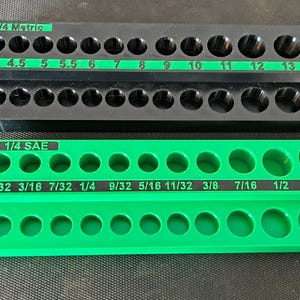 May include: A black metric socket organizer rail labeled 1/4 Metric with sizes 4 through 14 and a green SAE socket organizer rail labeled 1/4 SAE with sizes 5/32 through 9/16. Both organizers feature two rows of circular holes for storage.