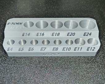 May include: A silver E-TORX socket organizer with two rows of circular holes labeled with sizes E4 through E24. The word "LEGACY" is printed on the bottom.