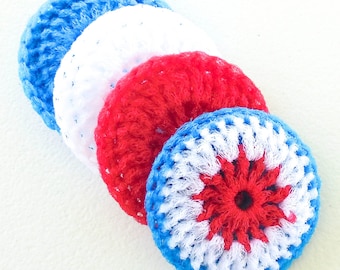 Puede incluir: Cuatro posavasos de ganchillo redondos en colores patrióticos: azul, blanco y rojo. Los posavasos tienen un aspecto texturizado. Uno de los posavasos presenta un diseño de estrella en el centro.