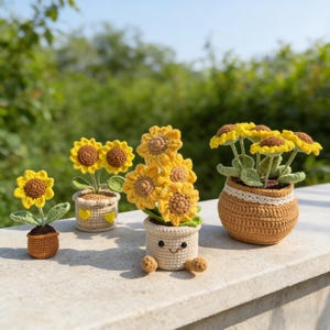 Puede incluir: Una colección de girasoles de ganchillo hechos a mano en macetas pequeñas. Los girasoles tienen pétalos amarillos y centros marrones. Las macetas son de varios colores, incluyendo marrón y beige, y algunas tienen detalles decorativos.