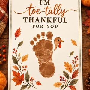 May include: A rectangular greeting card featuring the text I'M toe-tally THANKFUL FOR YOU in brown and orange. The center displays a brown footprint transformed into a turkey with a beak and wattle, surrounded by illustrations of autumn leaves.