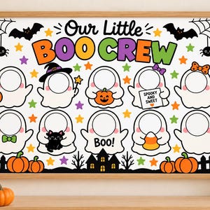 May include: A rectangular poster in a wooden frame featuring the text Our Little BOO CREW. The design includes ten white ghost illustrations with circular cutouts for faces, surrounded by colourful stars, bats, spiders, and pumpkins.