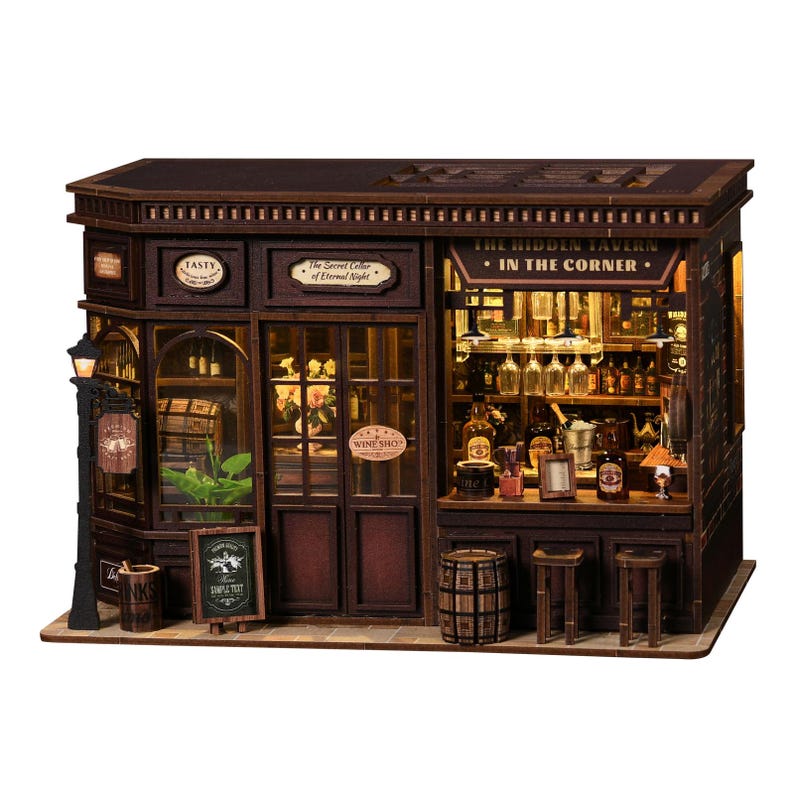 May include: A detailed miniature wooden tavern model, with the text "The Hidden Tavern In The Corner" above the entrance. The model includes a street lamp, a sign that says "Wine Shop," and a small chalkboard. The interior is lit, showcasing bottles and glasses.