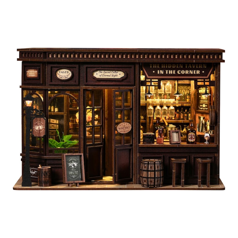 May include: A detailed miniature wooden tavern model. The model features a bar, tables, and a sign that reads "The Hidden Tavern - In The Corner." The model also includes a street lamp and a sign that reads "Tasty."