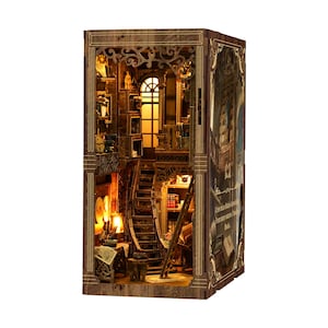 May include: A wooden bookshelf model with intricate details, featuring a staircase, ladder, and multiple shelves filled with miniature books and decor. The model has warm lighting, creating a cozy atmosphere. The exterior is decorated with ornate carvings.