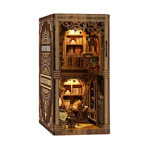 May include: A wooden miniature bookshelf model with an interior library scene. The model is brown with intricate details, including a ladder, books, and a balcony. The text "ANCIENT BOOK" and "COLLECTION ROOM" is visible on the side.