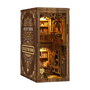 May include: A wooden bookshelf diorama with the words "Ancient Book Collection Room" on the side. The interior features miniature bookshelves, a ladder, and warm lighting, creating a cozy, inviting atmosphere. The diorama is intricately detailed with ornate carvings.