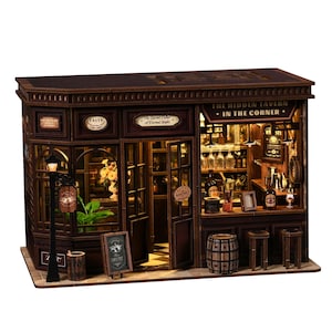 May include: A detailed miniature wooden tavern model. It features a bar, tables, and a street lamp. The sign reads "The Hidden Tavern - In The Corner". The interior is lit, showcasing bottles and glasses. The model is brown.